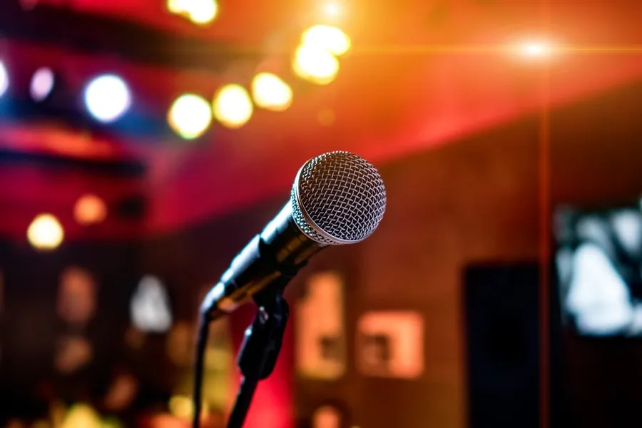 A karaoke microphone on its stand under coloured lights
